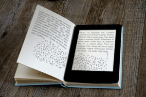 A book opened to the middle. The left side page is an ordinary printed page but the right side is an ebook reader!